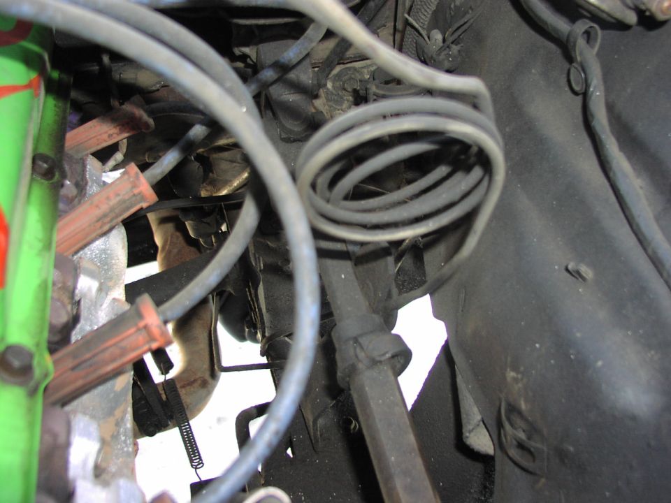 Engine compartment with spark plug wires, hoses, and metal components