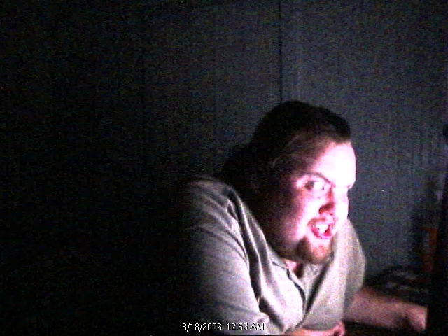 man with beard and short hair looking intensely at a screen, with text overlay showing date and time
