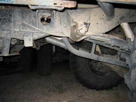 1991 Ford Bronco - Close-up of a vehicle's undercarriage, focusing on suspension and drivetrain parts.
