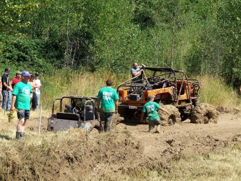 1977 Ford F-150 - Off-road vehicles are stuck in a mud pit during an event.