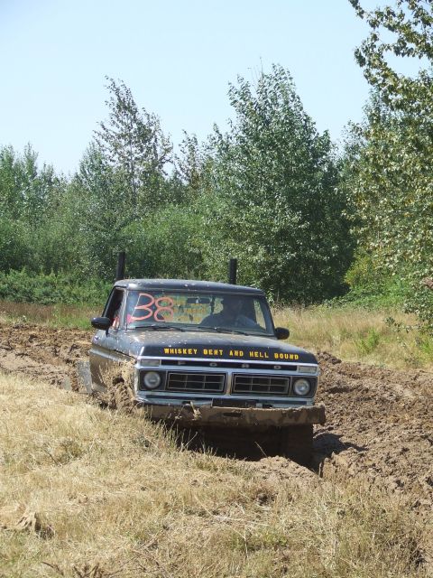 1977 Ford F-150 - This truck is navigating a muddy track with trees in the background. The number '38' is visible on the windshield.
