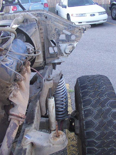 1978 Ford Bronco - The front suspension and chassis of a 1978 Ford Bronco are visible, with other vehicles in the background.