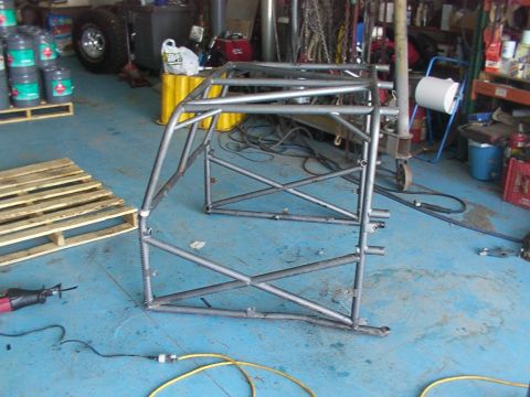 1978 Ford Bronco - A custom metal roll cage is assembled in a workshop, with various tools and supplies visible in the background.