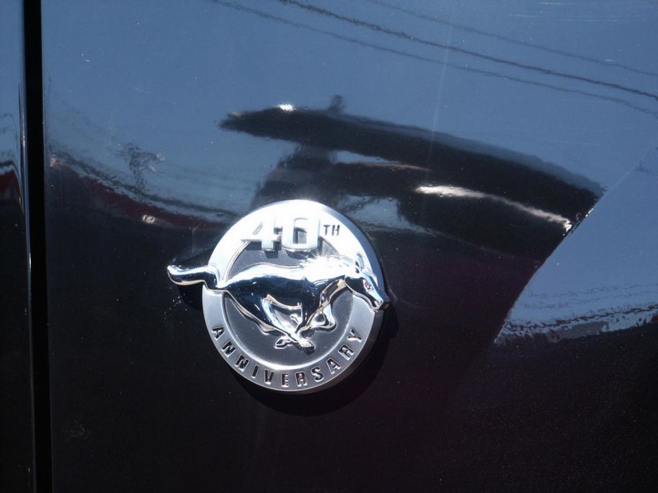 Black car fender with a chrome 40th Anniversary Mustang emblem