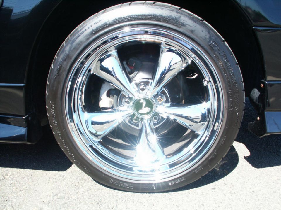 Chrome wheel with swan logo on black car