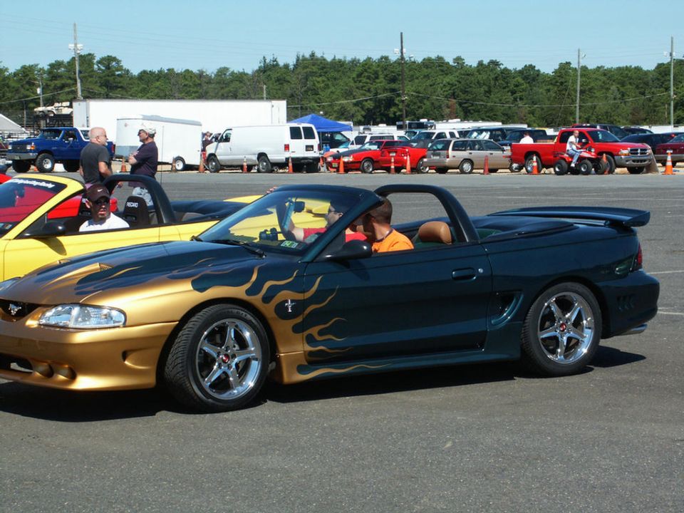 Dark green convertible with gold flames, side view