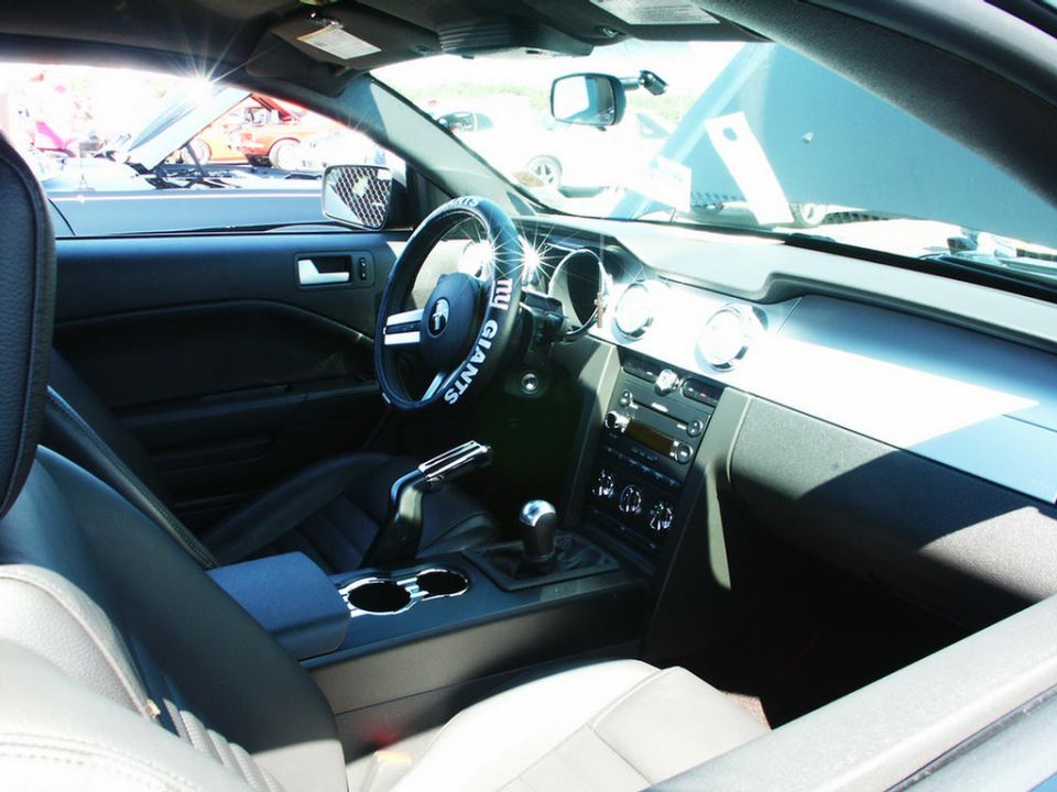 Car interior with a steering wheel cover that says "NY GIANTS", a manual transmission, and a Supermotors watermark