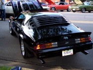 1972 Ford Ranchero - A black muscle car is parked on the street with its hood up, showing off its engine.
