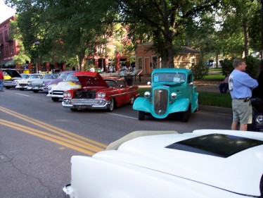 1972 Ford Ranchero - A collection of classic automobiles are displayed outdoors, with spectators observing the vehicles.