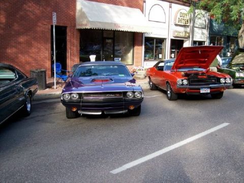 1972 Ford Ranchero - A purple muscle car is parked on a street next to other vehicles.