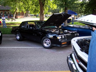 1972 Ford Ranchero - A black coupe, possibly from the 1980s, is displayed with its hood open at an outdoor event.