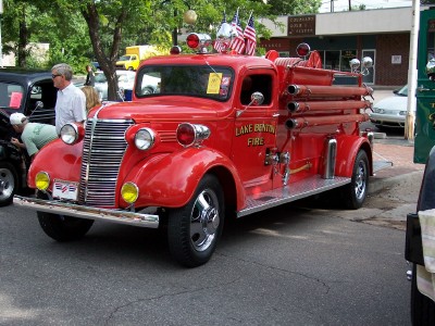 1972 Ford Ranchero - A vintage red fire truck is parked on a street, adorned with American flags and hoses.