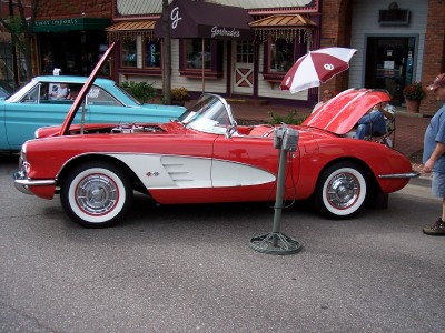 1972 Ford Ranchero - A red convertible with its hood open is parked next to a blue car on a street.