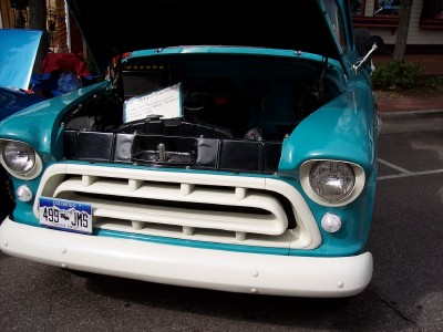 1972 Ford Ranchero - This turquoise truck displays its engine with the hood raised, revealing a distinctive white grille and bumper.