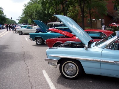 1972 Ford Ranchero - A line of classic cars with hoods open at a car show.
