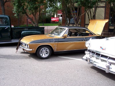 1972 Ford Ranchero - A two-tone coupe with its hood open is parked on a street next to other vehicles.