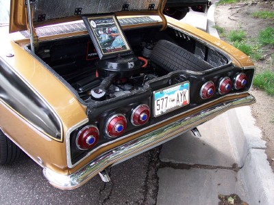 1972 Ford Ranchero - Gold 1965 Chevrolet Corvair Monza rear view with trunk open, showing engine and spare tire.