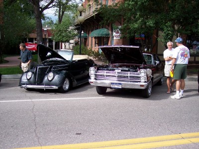 1972 Ford Ranchero - Two vintage automobiles are displayed with their engines exposed, attracting attention from onlookers.