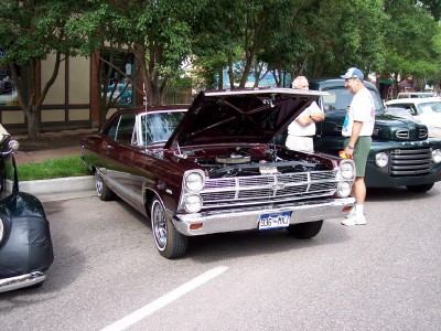 1972 Ford Ranchero - A maroon 1966 Ford Fairlane is parked with its hood up, revealing the engine bay.
