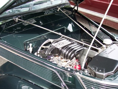 1972 Ford Ranchero - The engine bay of a classic car, a polished V8 engine and dark green fenders.