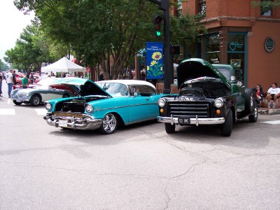 1972 Ford Ranchero - A turquoise and white 1957 Chevrolet Bel Air is parked on a street with its hood open, alongside other classic vehicles.