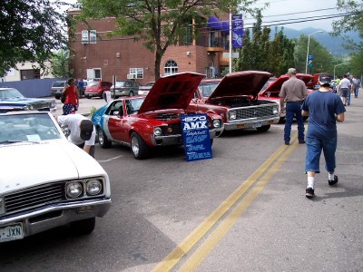 1972 Ford Ranchero - A blue sign in front of the 1970 AMC AMX displays information about the car.