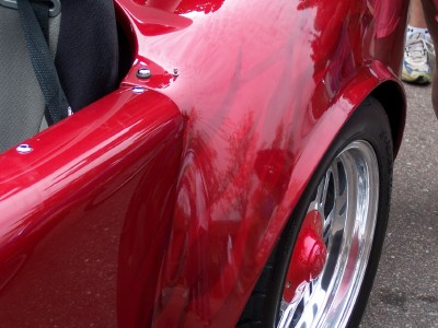 1972 Ford Ranchero - Close-up view of a shiny red car fender and wheel, custom flame paint and chrome rims.