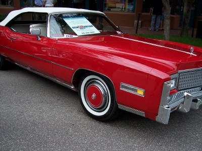 1972 Ford Ranchero - A red convertible with a white top is parked on the street, displaying a sign on its windshield.