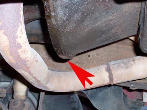 1978 Ford Bronco - A red arrow indicates a leak from the oil pan onto the exhaust pipe.