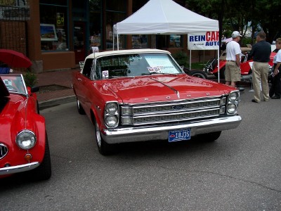 1972 Ford Ranchero - A classic red Ford convertible is displayed at an outdoor event, with a white tent and other vehicles in the background.