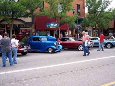 1972 Ford Ranchero - A street scene with multiple cars on display, possibly at a car show.