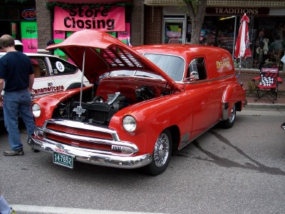 1972 Ford Ranchero - Red panel van with hood open at a car show. Another vehicle is parked nearby.