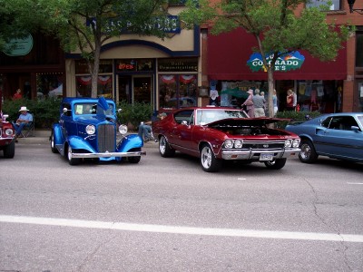 1972 Ford Ranchero - A red 1969 Chevrolet Chevelle SS is parked on a street with its hood open, alongside other vehicles.