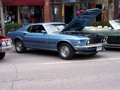 1972 Ford Ranchero - A blue 1969 Ford Mustang Mach 1 is parked with its hood open, next to another vehicle.