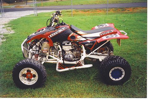 1992 Ford Mustang - Side view of a custom racing ATV parked on grass. No year is visible.