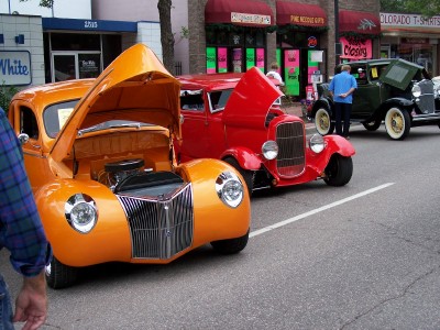 1972 Ford Ranchero - Three vintage cars displayed with hoods open on a street during an event.