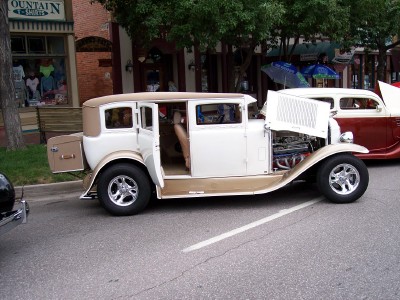 1972 Ford Ranchero - A modified sedan with its doors and hood open, parked on a street.