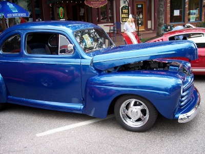 1972 Ford Ranchero - A blue 1948 Ford coupe is parked on the street with its hood open, revealing the engine.