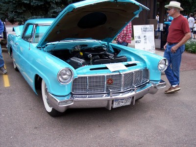1972 Ford Ranchero - 1956 Lincoln Continental Mark II, front view with hood open. A man stands next to the car.