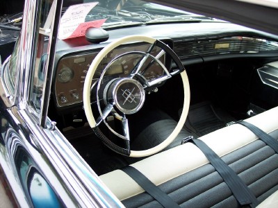 1972 Ford Ranchero - The interior of a classic car features a distinctive steering wheel and two-tone seating with seatbelts.