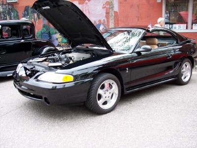 1972 Ford Ranchero - A black 1994 Ford Mustang is parked with its hood open, revealing the engine bay.