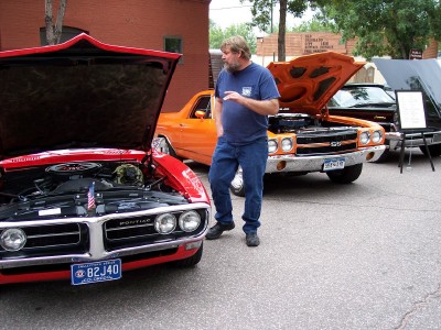 1972 Ford Ranchero - Three classic cars are displayed with their hoods open at an outdoor event.
