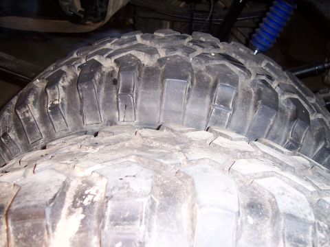 1983 Ford Bronco - Close-up view of stacked off-road tires with deep, blocky tread.