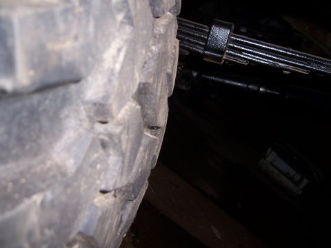 1983 Ford Bronco - A close-up view of a tire and its associated leaf spring assembly, likely from a truck or SUV.