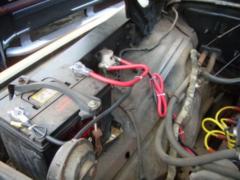 1971 Ford F-100 - Close-up view of a vehicle's battery and associated wiring, showing the positive and negative terminals and cables.