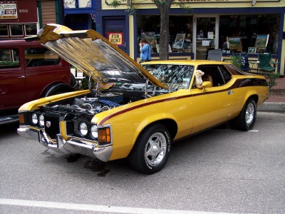 1972 Ford Ranchero - Yellow 1972 Ford Ranchero on display with hood open, a small dog visible in the driver's window.