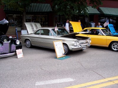 1972 Ford Ranchero - Two classic cars, a gold Chevrolet Corvair and a yellow car, displayed outdoors with hoods open.