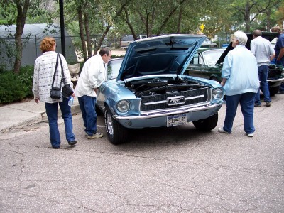 1972 Ford Ranchero - People examine a classic Ford Mustang at an outdoor gathering, with other vehicles visible in the background.