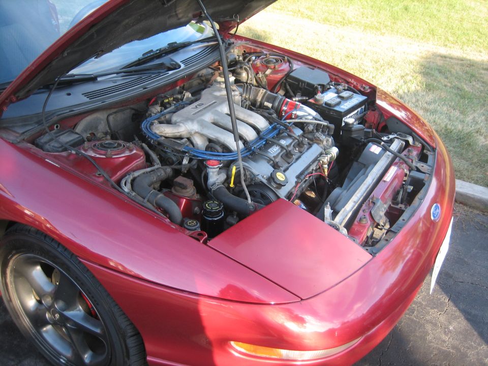 Red 1993 Ford Probe with hood open, showing the V6 engine