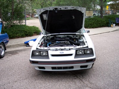 1972 Ford Ranchero - A white Ford Mustang is parked with its hood open, revealing the engine bay.